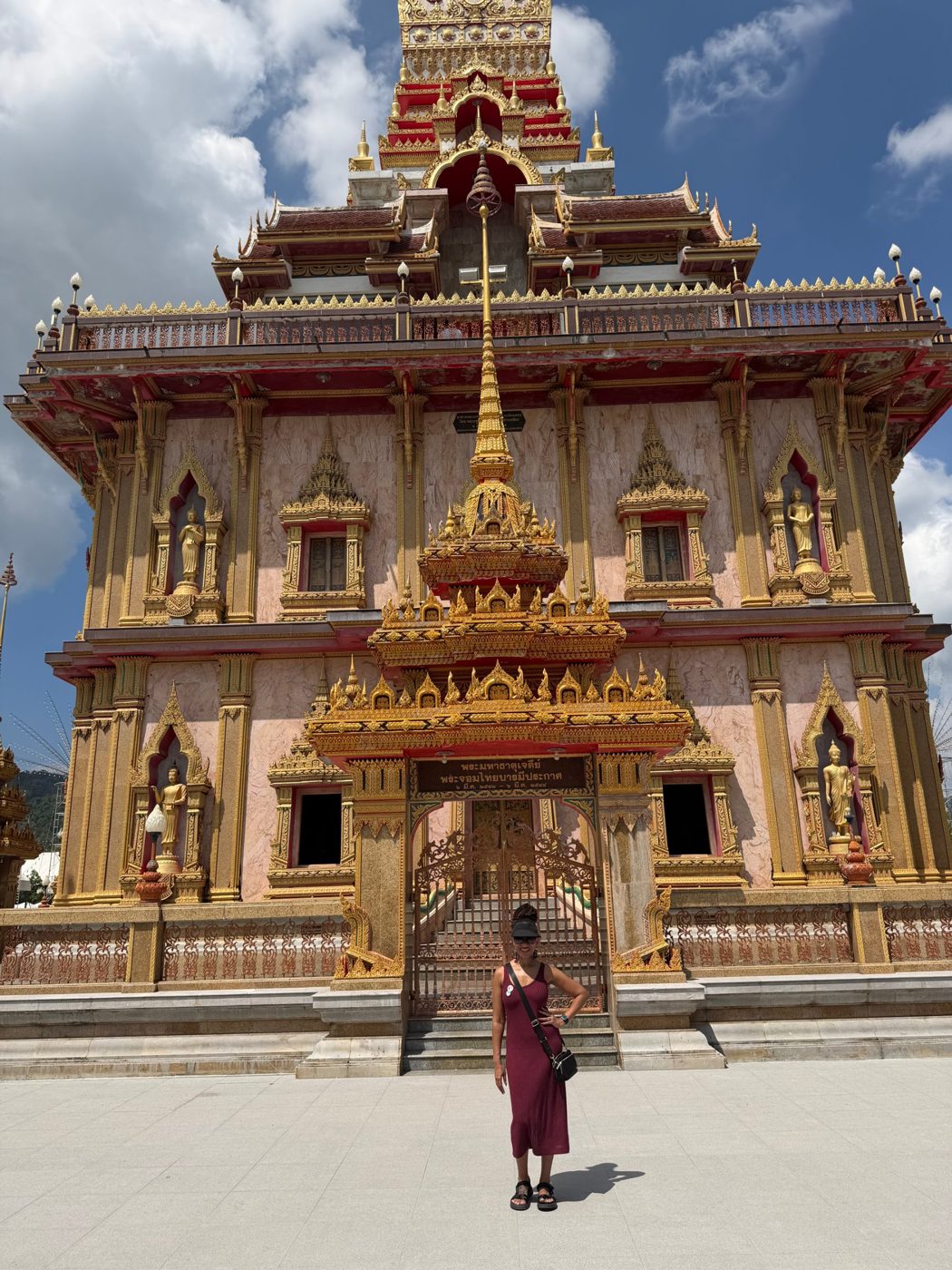 Brittney in front of an ornate red and gold temple