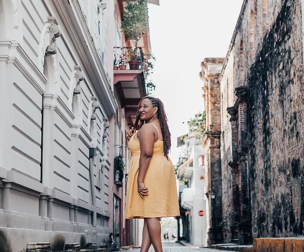 A traveler in a yellow dress on a cobblestone street